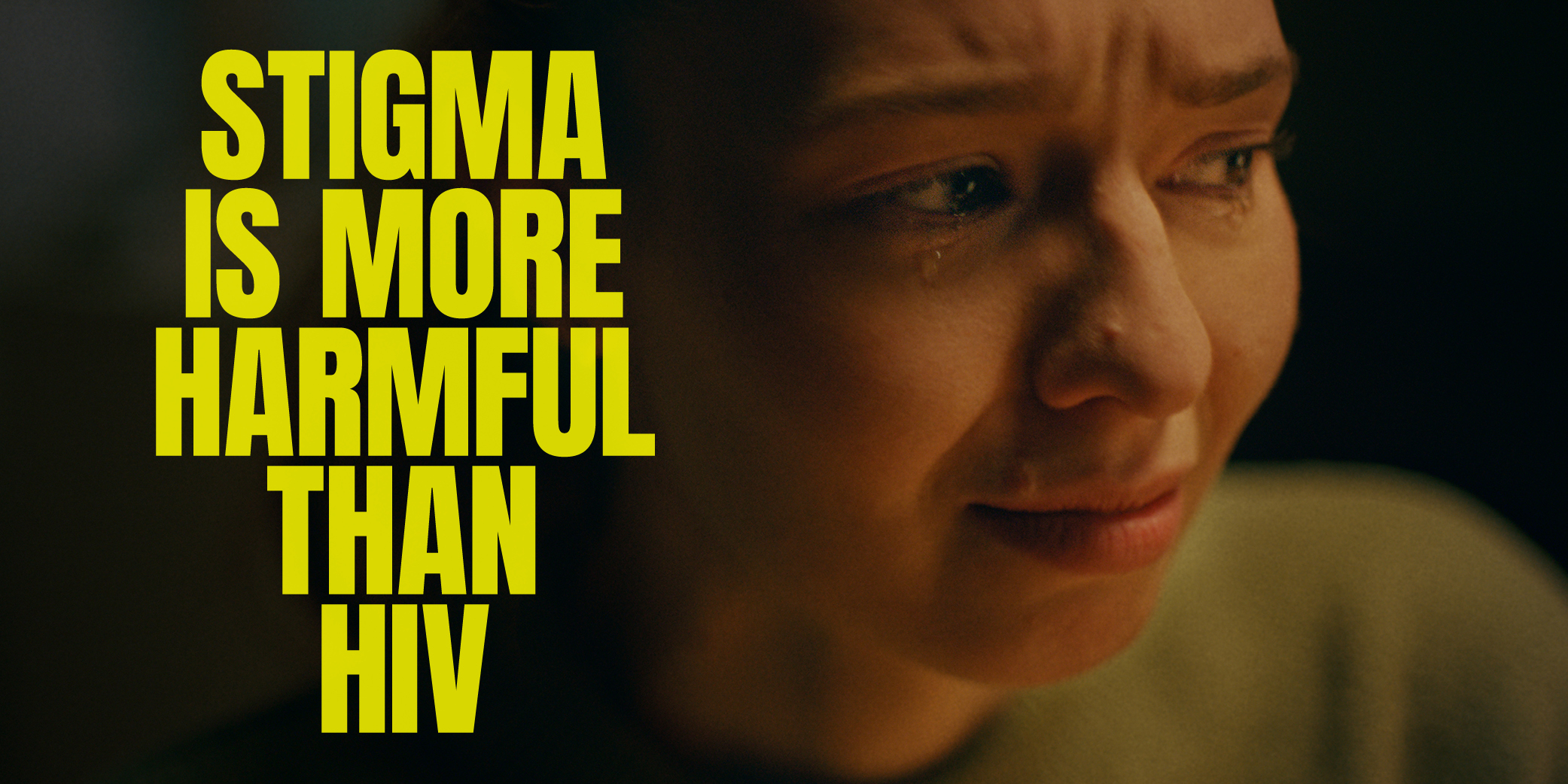 Image of a person in distress and text stigma is more harmful than HIV